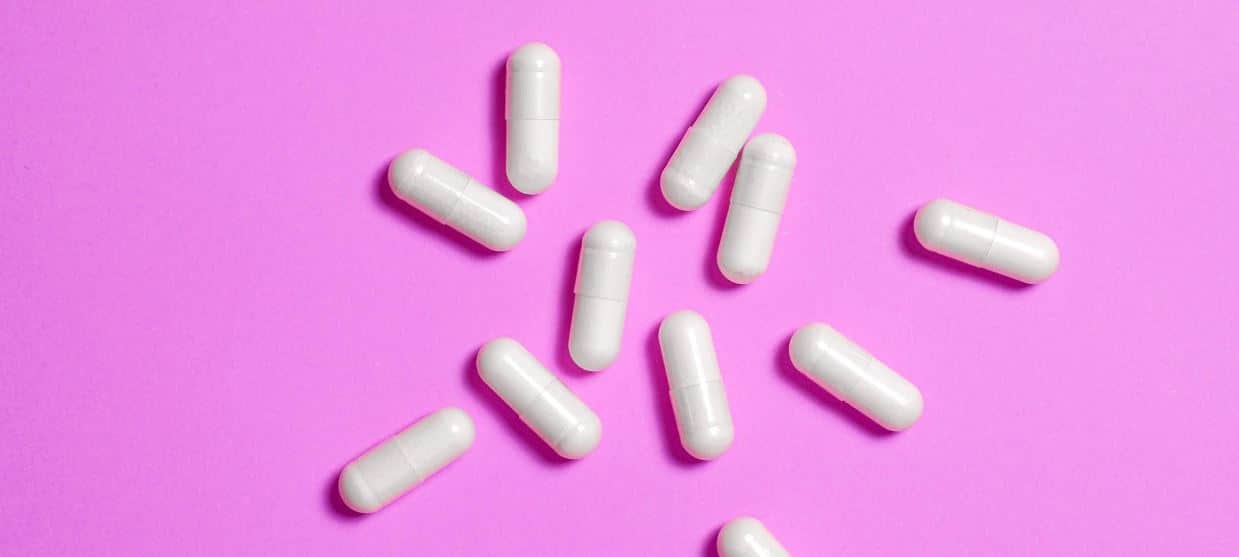 Pink Pills White pills on pink background